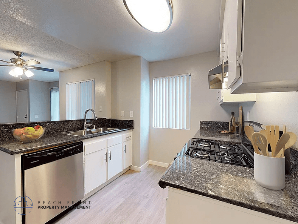 A kitchen with a black stove top oven and white cabinets.